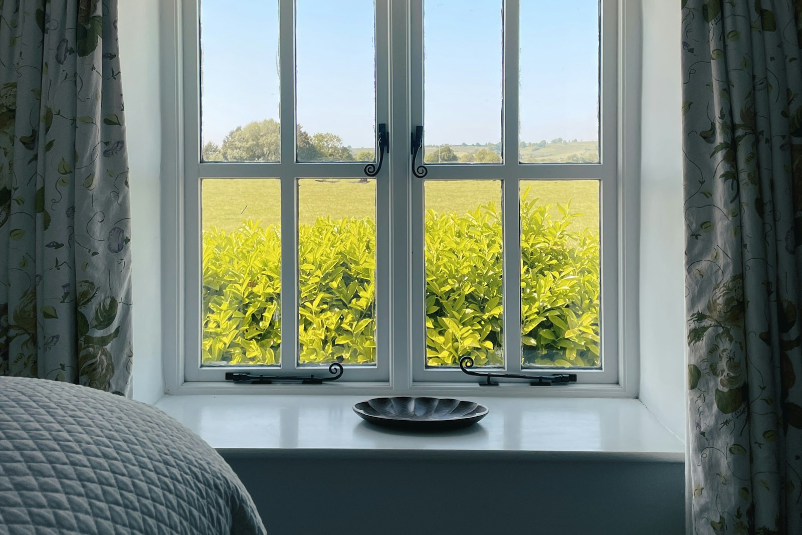 Casement window over the fields, with the bed alongside